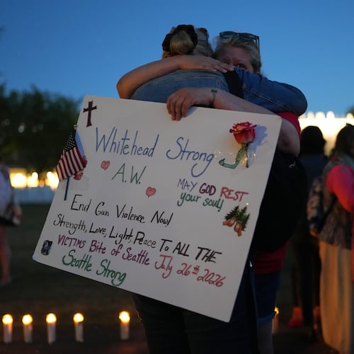 Michelle Whitehead, right, and her sister Judy Whitehead, left, both cousin of victim Ashley Whitehead, during the vigil for victims the day after a shooting at Seattle Center during the Bite of Seattle food festival, Monday, July 27, 2026, in Seattle. (AP Photo/Lindsey Wasson)