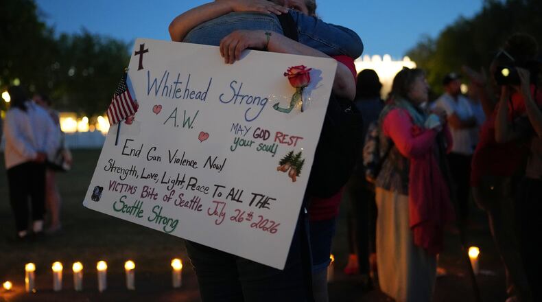 Michelle Whitehead, right, and her sister Judy Whitehead, left, both cousin of victim Ashley Whitehead, during the vigil for victims the day after a shooting at Seattle Center during the Bite of Seattle food festival, Monday, July 27, 2026, in Seattle. (AP Photo/Lindsey Wasson)