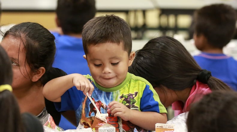 Three-year-old Jesus Miguel Francisco enjoys a free lunch with family members at Highland Elementary in Lake Worth Friday (Bruce R. Bennett / The Palm Beach Post)