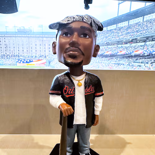 A Tupac Shakur bobblehead is displayed for the Baltimore Orioles' giveaway at a baseball game against the Athletics on Friday, May 8, 2026, in Baltimore. (AP Photo/Noah Trister)