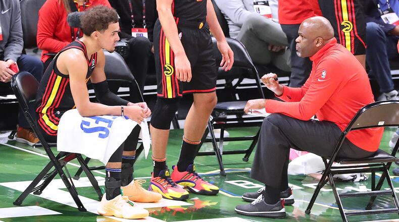 Hawks interim head coach Nate McMillan confers with Trae Young during a time out after falling behind 57-41 against the Milwaukee Bucks in the second quarter of Game 2 of the Eastern Conference finals Friday, June 25, 2021, in Milwaukee. (Curtis Compton / Curtis.Compton@ajc.com)