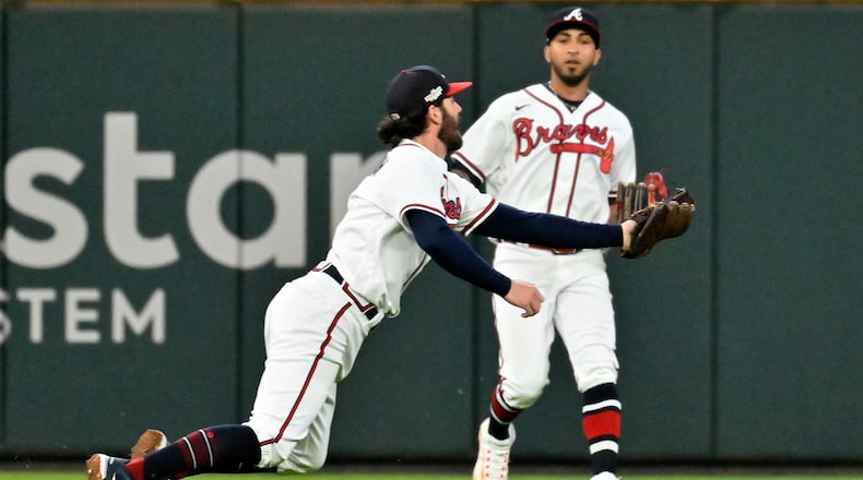 Atlanta Braves shortstop Dansby Swanson (7) makes an over the shoulder catch of the pop up by Philadelphia Phillies’ J.T. Realmuto during the sixth inning of Game 2 of the National League Division Series at Truist Park in Atlanta on Wednesday, Oct. 12, 2022. (Hyosub Shin / Hyosub.Shin@ajc.com)