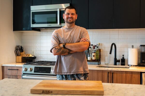 A man stands with his arms crossed in a kitchen
