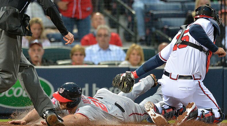 Washington Nationals second baseman Dan Uggla (26) reaches home plate past the tag of Atlanta Braves catcher A.J. Pierzynski (15) on a 3-RBI single by Washington Nationals starting pitcher Jordan Zimmermann (27) in the 4th inning at Turner Field on Wednesday, April 29, 2015.