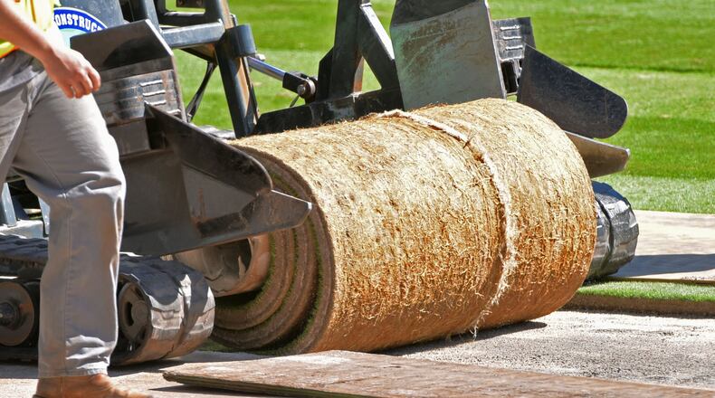 Workers lay sod in the infield at SunTrust Park on Saturday. HYOSUB SHIN / HSHIN@AJC.COM