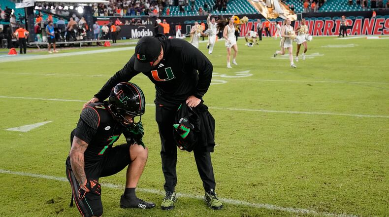 Miami wide receiver Xavier Restrepo is consoled after Georgia Tech beat Miami 23-20 during an NCAA college football game, Saturday, Oct. 7, 2023, in Miami Gardens, Fla. (AP Photo/Wilfredo Lee)