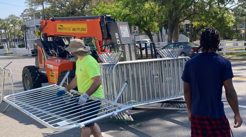 Tybee city workers place traffic barricades along U.S. 80 Tuesday in preparation for the Orange Crush beach party. (Adam Van Brimmer/AJC)