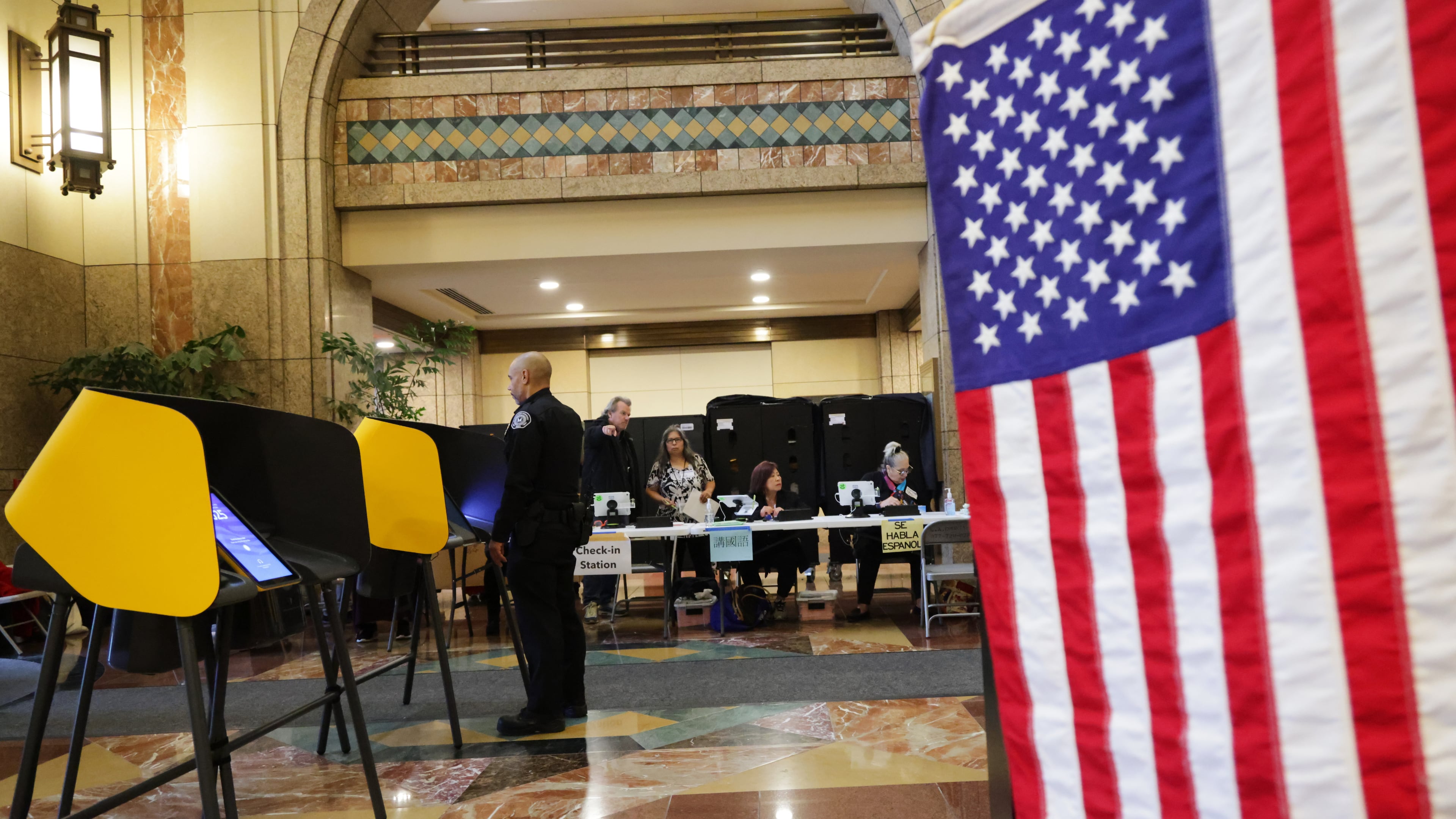 Workers wait for voters to arrive at a polling station on Tuesday, Nov. 4, 2025, in Los Angeles. (AP Photo/Ethan Swope)