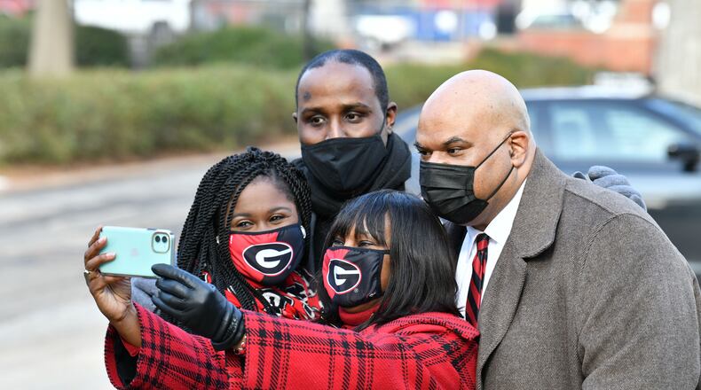 January 9, 20201 Athens - Ericka Davis (center) holds her iPhone to take a photograph with (clockwise from left), Shontel Cargill, Jeff Brown and Hamilton Holmes Jr. after they rang the Chapel Bell to honor the 60th anniversary of desegregation of the University of Georgia outside the UGA Chapel on the campus in Athens on Saturday, January 9, 2021. On January 9, 1961, two courageous students, Hamilton Holmes and Charlayne Hunter, took heroic steps on the University of GeorgiaÕs campus to enroll as students followed by Mary Frances Early, who entered graduate school that summer. Their legacies continue as they have contributed a lifetime of public service to their communities. Because of these students, the university now boasts a diverse campus made of numerous nationalities, races and ethnicities. (Hyosub Shin / Hyosub.Shin@ajc.com)