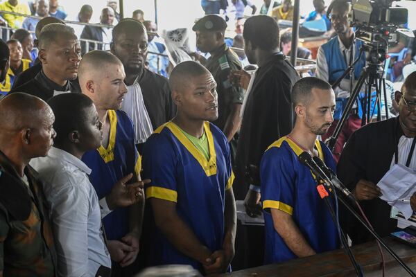 FILE - From left Tyler Thompson Jr., Marcel Malanga and Benjamin Reuben Zalman-Polun, right, all American citizens, face the court in Kinshasa with 52 other defendants on June 7, 2024, accused of a role in last month's attempted coup in Congo led by little-known opposition figure Christian Malanga in which six people were killed. (AP Photo/Samy Ntumba Shambuyi, File)