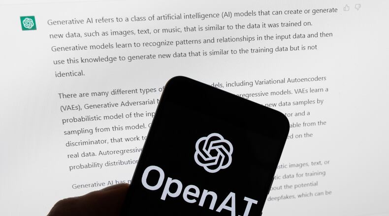 FILE - The OpenAI logo is displayed on a mobile phone in front of a computer screen with output from ChatGPT, March 21, 2023, in Boston. (AP Photo/Michael Dwyer, File)
