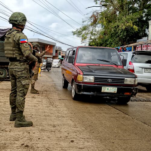 In this photo taken with a smartphone, Army soldiers check the flow of vehicular traffic along the highway in Marantao town, Lanao del Sur province, southern Philippines on Sunday Sept 13, 2026. (AP Photo/ Froilan Gallardo)
