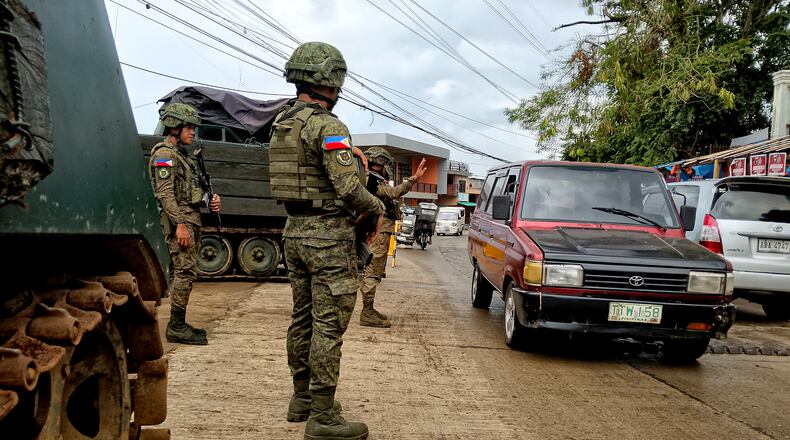 In this photo taken with a smartphone, Army soldiers check the flow of vehicular traffic along the highway in Marantao town, Lanao del Sur province, southern Philippines on Sunday Sept 13, 2026. (AP Photo/ Froilan Gallardo)