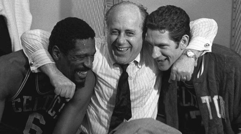 Boston Celtics general manager Red Auerbach, center, hugs Celtics stars Bill Russell, left, and John Havlicek after defeating the Los Angeles Lakers to win the NBA Championship, in Los Angeles, in this May 3, 1968 photo. (AP Photo/File)