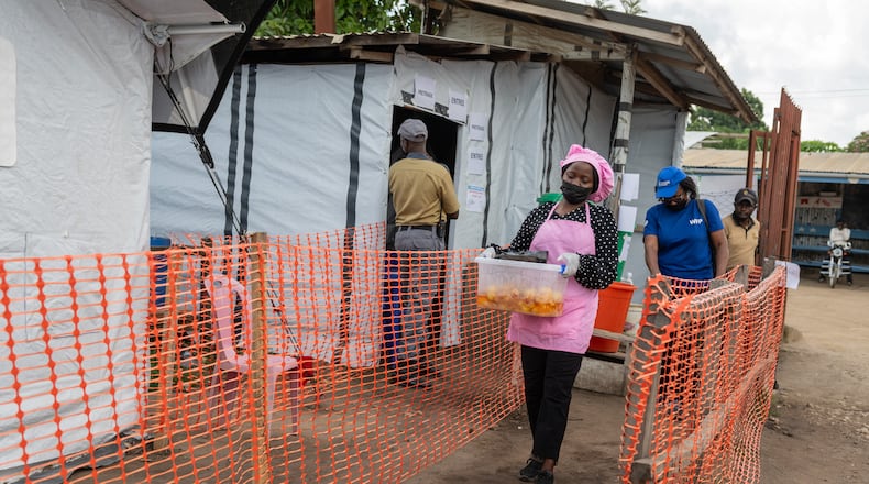 Kavugho Hortense, a cook, delivers meals to the medical staff and Ebola patients at the Evangelical Medical Center (CEM) in Bunia, Congo, Monday, June 1, 2026. (AP Photo/Moses Sawasawa)