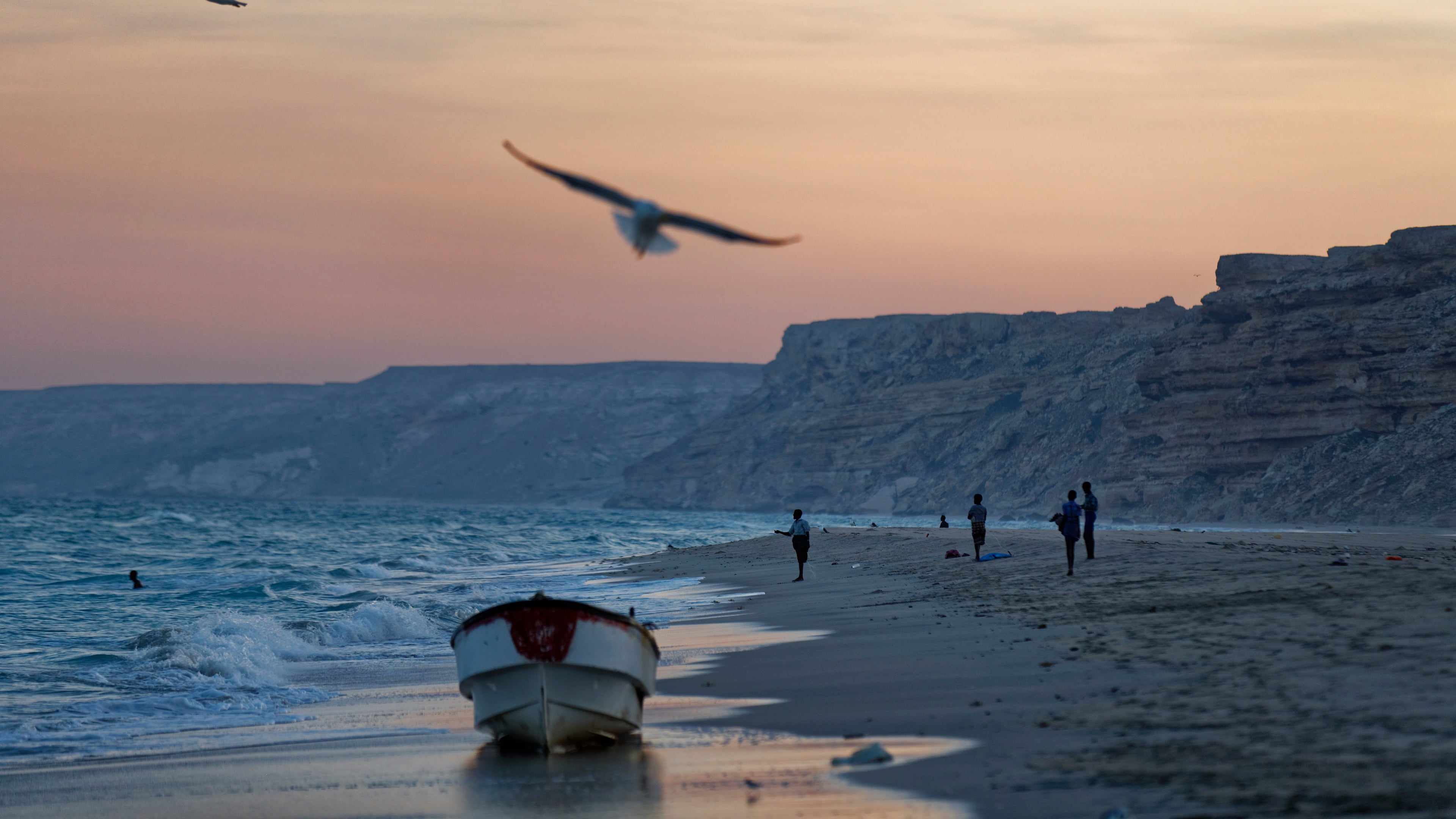 FILE - Fishermen stand on the Indian Ocean beach at dusk in the former pirate village of Eyl, in Somalia's semiautonomous northeastern state of Puntland, Somalia, Monday March 6, 2017. (AP Photo/Ben Curtis, File)
