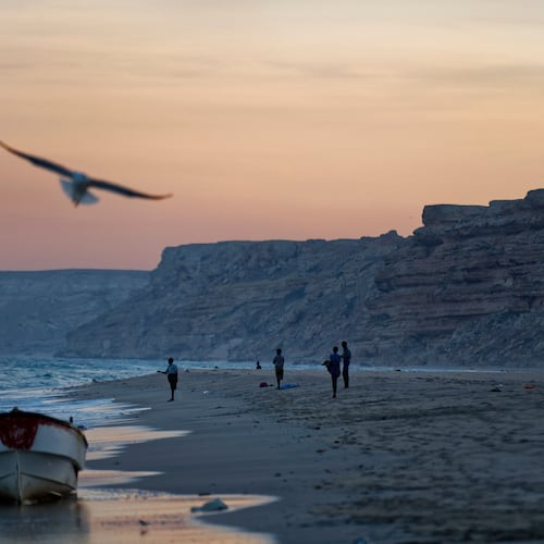 FILE - Fishermen stand on the Indian Ocean beach at dusk in the former pirate village of Eyl, in Somalia's semiautonomous northeastern state of Puntland, Somalia, Monday March 6, 2017. (AP Photo/Ben Curtis, File)