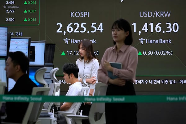 Currency traders work near a screen showing the Korea Composite Stock Price Index (KOSPI) and the foreign exchange rate between U.S. dollar and South Korean won, right, at the foreign exchange dealing room of the KEB Hana Bank headquarters in Seoul, South Korea, Wednesday, May 14, 2025. (AP Photo/Ahn Young-joon)