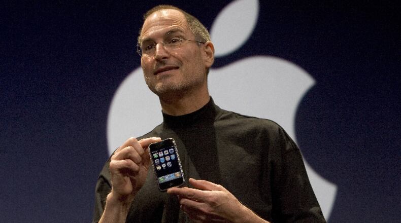 Apple CEO Steve Jobs holds up the new iPhone that was introduced at Macworld on January 9, 2007 in San Francisco, California. The new iPhone will combine a mobile phone, a widescreen iPod with touch controls and a internet communications device with the ability to use email, web browsing, maps and searching. The iPhone will start shipping in the US in June 2007.