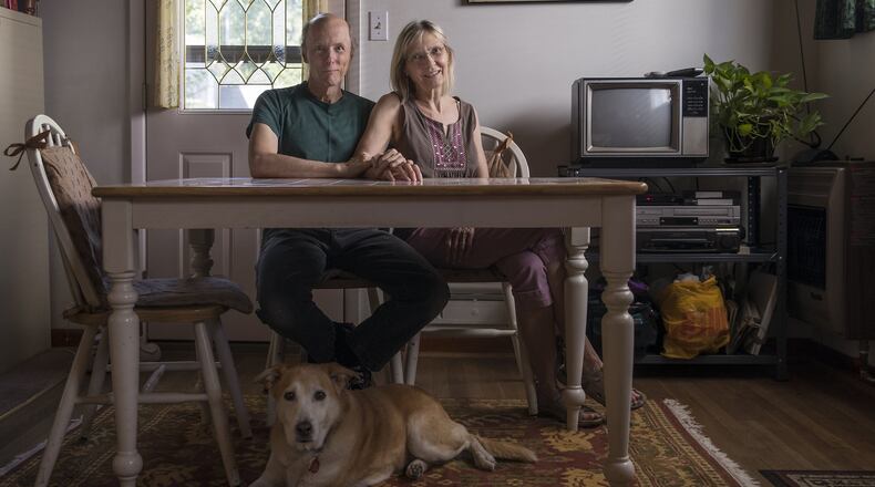Glenn Phillips and his wife Katie Oehler with their dog Cora at their residence in Brookhaven. Alyssa Pointer/alyssa.pointer@ajc.com)