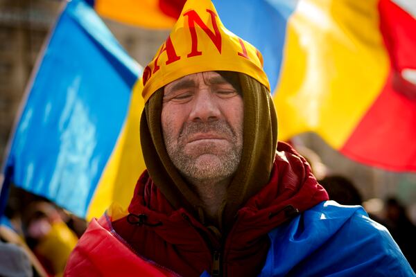 FILE - A supporter of Calin Georgescu, the winner of Romania's first round of presidential election, annulled by the Constitutional Court, attends a protest outside the government headquarters in Bucharest, Feb. 22, 2025. (AP Photo/Vadim Ghirda, File)