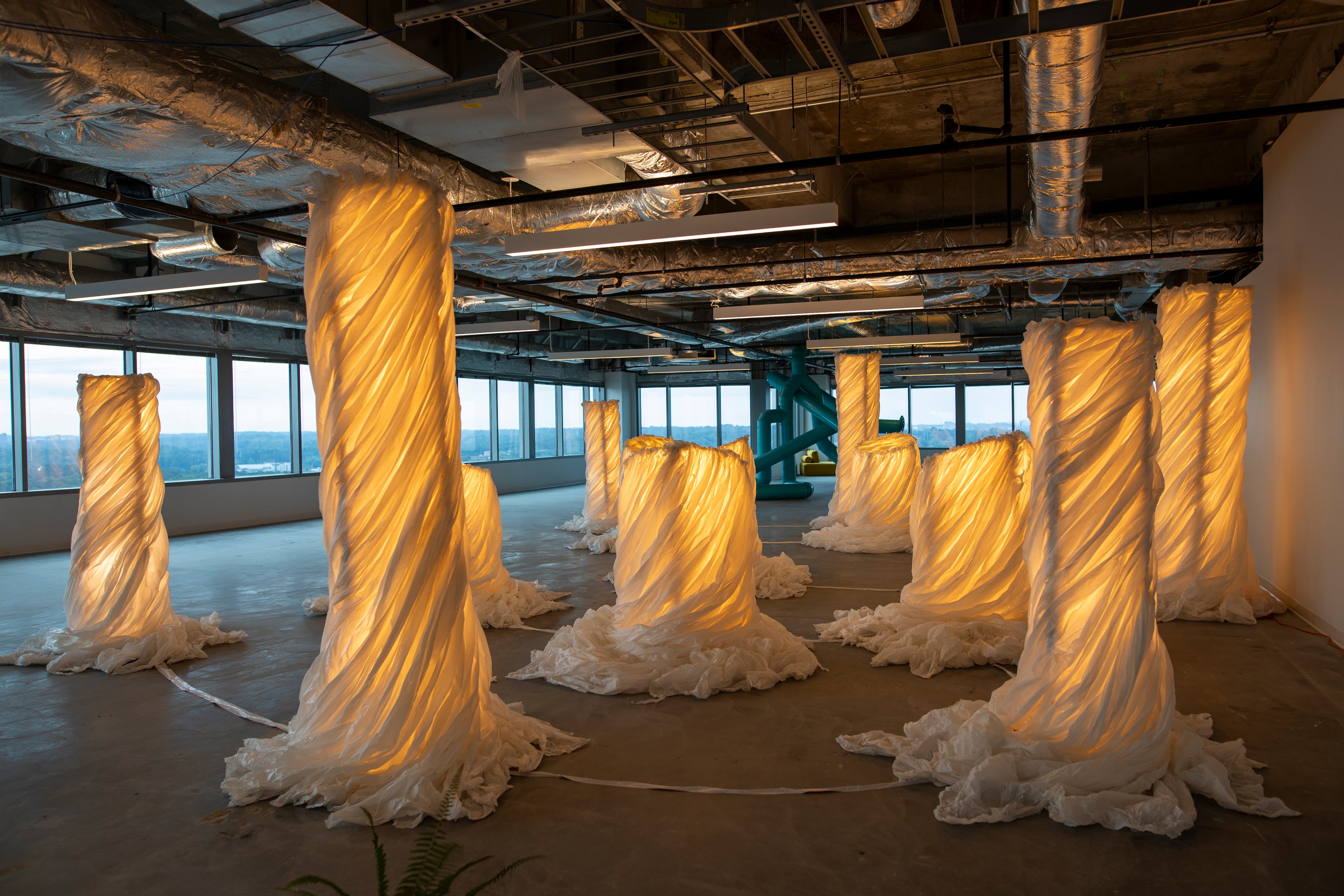 Roberto Rafael Navarrete’s "Boveda" is a series of fabric-wrapped columns that glow from within, presented as bovedas (altars). (Isadora Pennington/ArtsATL)
