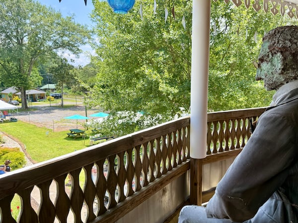 A statue of folk artist Howard Finster sits on the upper balcony of The World's Folk Art Church. The statue sits watch, looking out over Paradise Garden. The church reopened in June 2025 after being closed for more than 25 years. Danielle Charbonneau/AJC