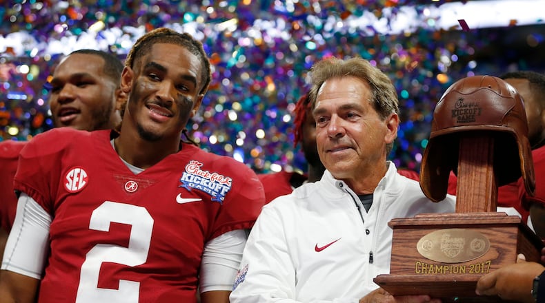 Alabama quarterback Jalen Hurts and Alabama head coach Nick Saban stand with the Leather Helmet trophy after the Florida State game on Sept. 3, 2017, in Atlanta. Alabama won 24-7.