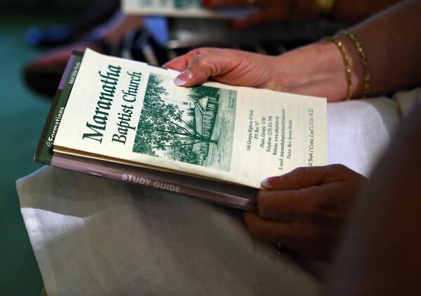 A member of the congregation looks over the church bulletin while Jimmy Carter teaches the Sunday school lesson at Maranatha Baptist Church on Sunday, June 15, 2014, in Plains. CURTIS COMPTON / CCOMPTON@AJC.COM