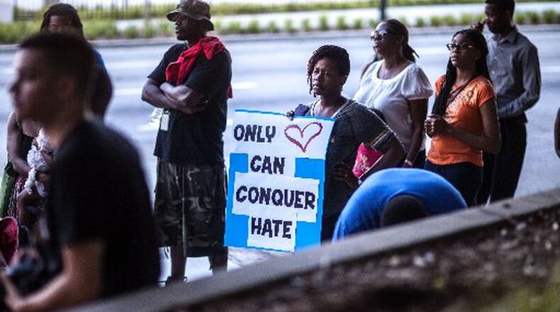 Katlyne Hill holds a sign at the state Capitol before a recent Remembrance March in Atlanta for the nine people killed at the historic Emanuel AME Church in Charleston, S.C. BRANDEN CAMP / SPECIAL