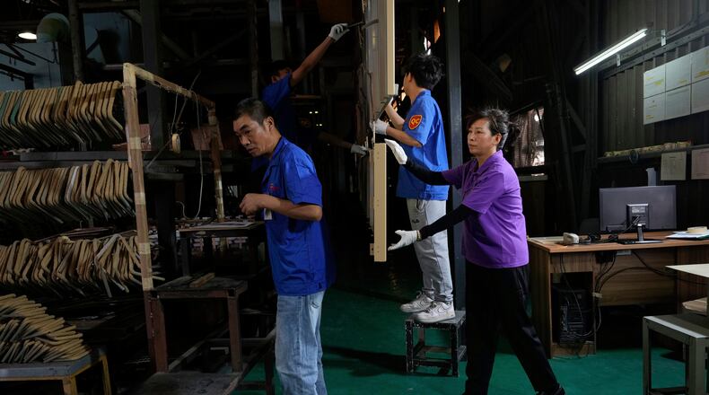 FILE - Workers check aluminum panels produced at a factory of Kam Pin Industrial (HK) Ltd, in Dongguan city in southern China's Guangdong province April 17, 2025. (AP Photo/Ng Han Guan, File)