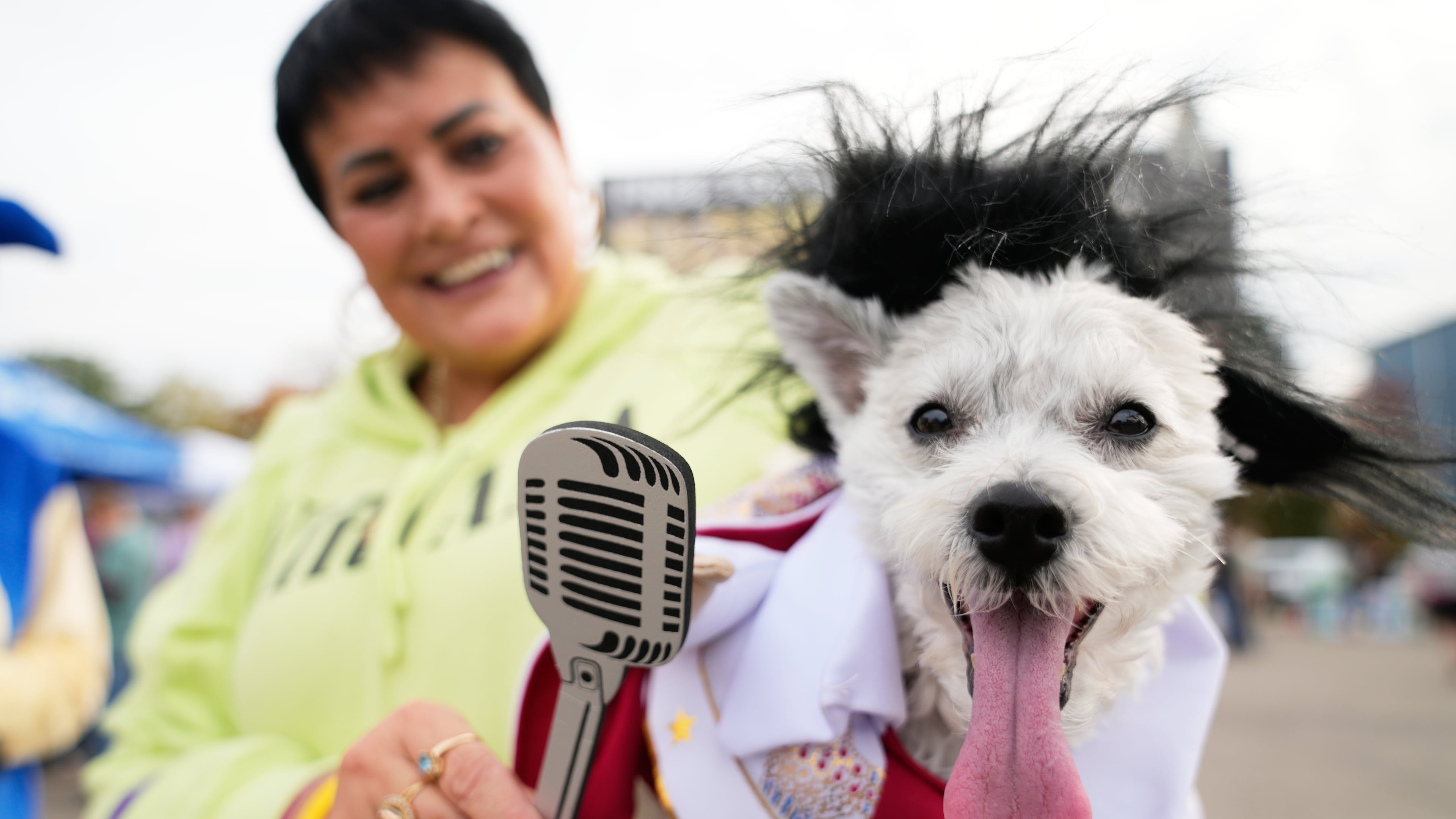 Michelle Dixon, of Laingsburg, holds her dog Abu, who is dressed as singer Elvis Presley, during an event for dog trick-or-treating, Friday, Oct. 17, 2025, in Lansing, Mich. (AP Photo/Ryan Sun)