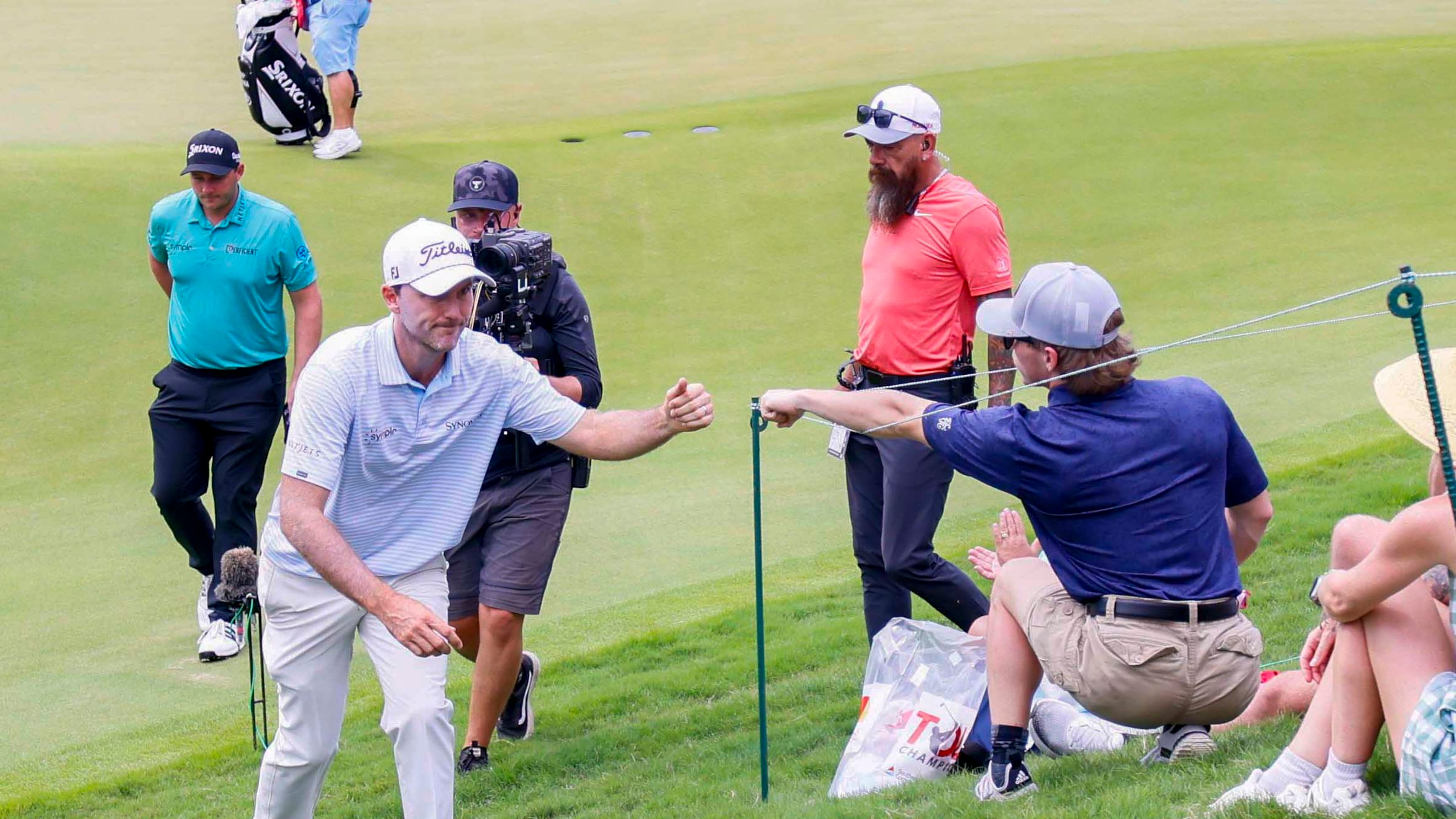 Russell Henley fist-bumps a fan as he leaves the course after leading at the end of the first round of the PGA Tour Championship at East Lake Golf Club on Thursday, Aug. 21, 2025, in Atlanta. (Miguel Martinez/AJC)