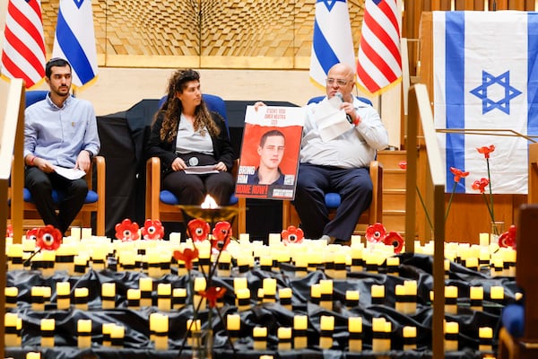 Bobby Harris (right) displays a portrait of Oct. 7 hostage Omer Neutra as he shares a personal story at the Ahavath Achim Synagogue on Sunday.