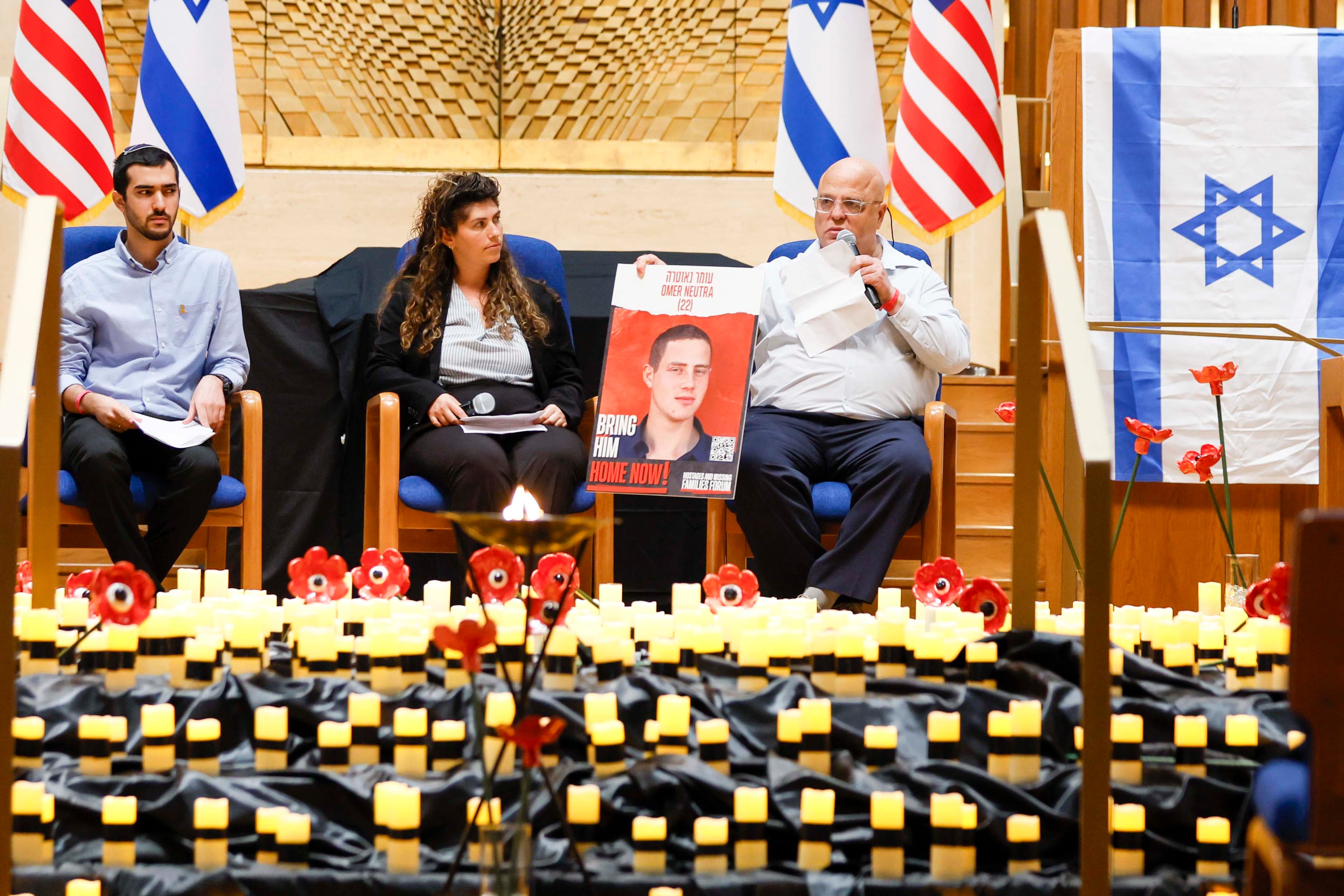 Bobby Harris (right) displays a portrait of Oct. 7 hostage Omer Neutra as he shares a personal story at the Ahavath Achim Synagogue on Sunday.