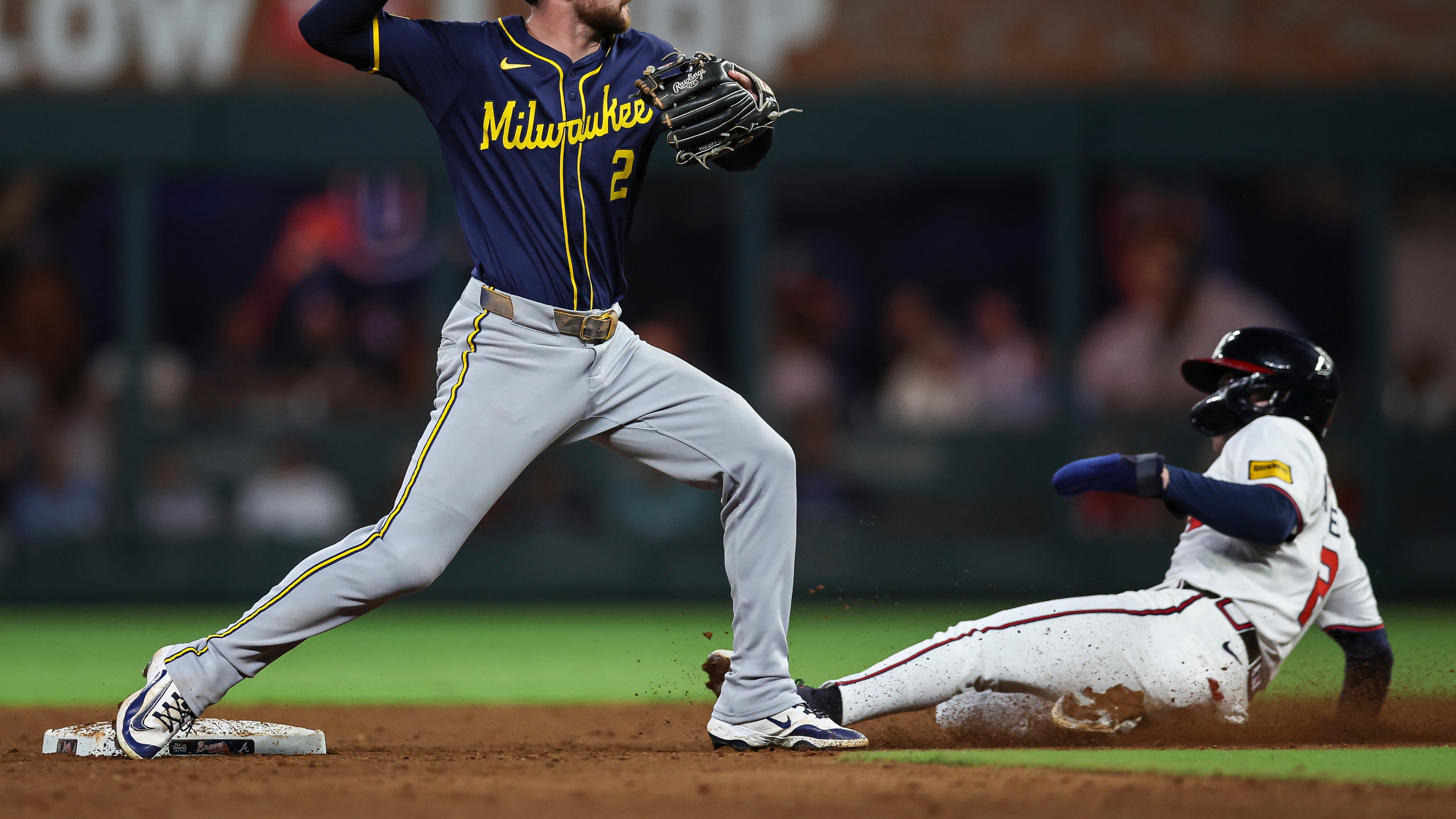 Milwaukee Brewers second baseman Brice Turang (2) tags second base before throwing to first base in the fifth inning of a baseball game against the Atlanta Braves, Wednesday, Aug. 6, 2025, in Atlanta. (AP Photo/Colin Hubbard)