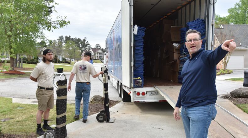 Chris New (right), owner of Barnes Van Lines, supervises workers Joe Nowak (left) and Anson Strickland while moving a family in Villa Rica on Thursday, April 15, 2021. (Hyosub Shin / Hyosub.Shin@ajc.com)