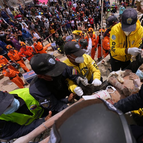 Rescue workers carry a man rescued from the rubble of a building that collapsed in the earthquakes that struck La Guaira, Venezuela, Sunday, June 28, 2026. (AP Photo/Matias Delacroix)
