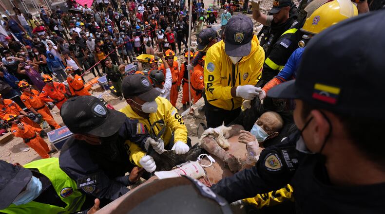 Rescue workers carry a man rescued from the rubble of a building that collapsed in the earthquakes that struck La Guaira, Venezuela, Sunday, June 28, 2026. (AP Photo/Matias Delacroix)