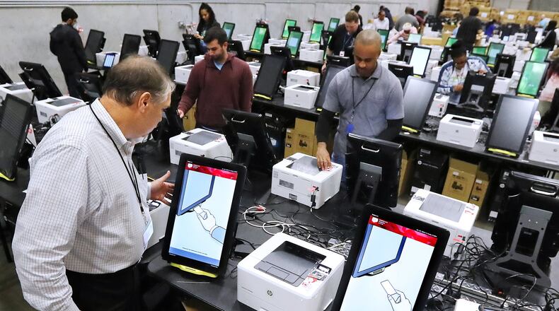 Project manager Tom Feehan looks over some of the state’s new voting machines Tuesday while thousands are tested and packed in a Fulton County warehouse. Curtis Compton ccompton@ajc.com