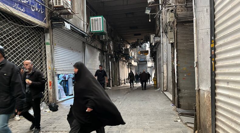 People walk as shops are closed during protests in Tehran's centuries-old main bazaar, Iran, Tuesday, Jan. 6, 2026. (AP Photo/Vahid Salemi)