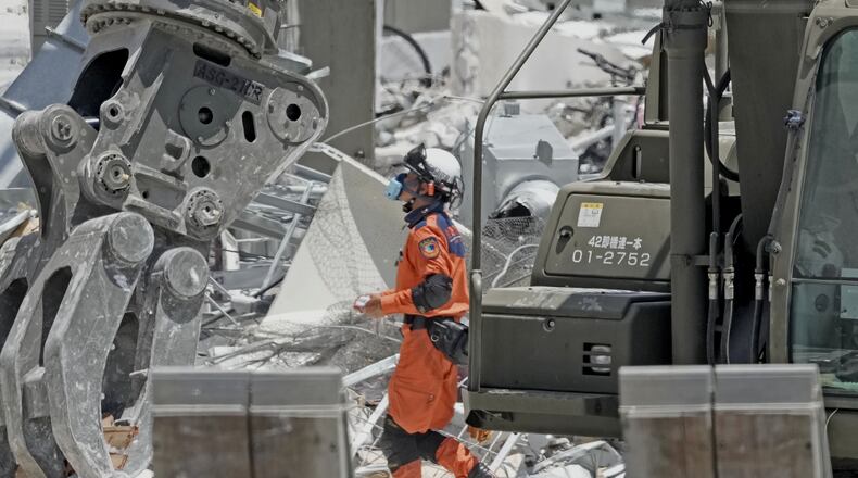 A firefighter searches the damaged AEON Mall following an explosion triggered by an earthquake in Kashima, Kumamoto Prefecture, southern Japan, Friday, July 31, 2026. (Kai Naito/Kyodo News via AP)