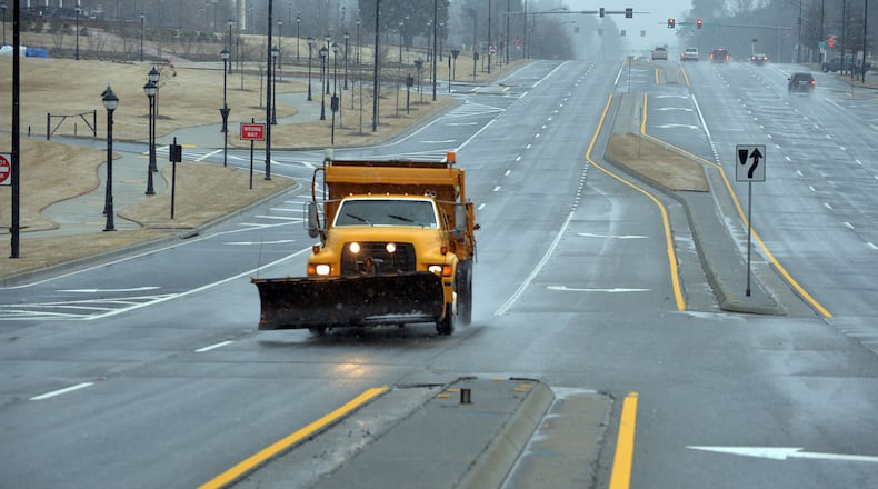 A lone GDOT snowplow patrols Buford Highway looking for trouble spots on February 25. School districts, government offices and businesses closed in anticipation of possible snow and ice. For the most part, the metro area was spared. KENT D. JOHNSON/KDJOHNSON@AJC.COM