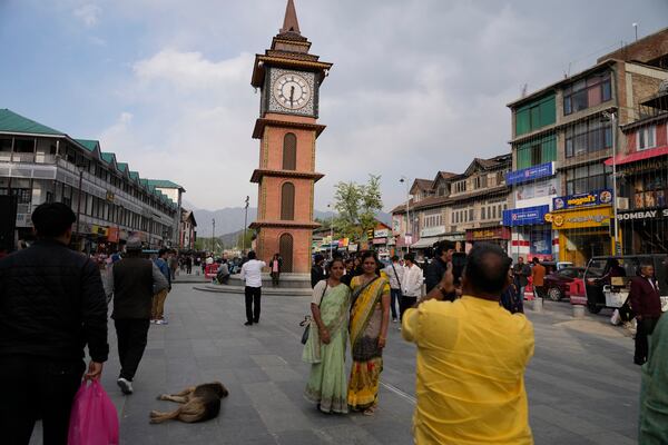 Indian tourists take pictures near a clock tower at city centre in Srinagar, Indian controlled Kashmir,Tuesday, April. 22, 2025. (AP Photo/Mukhtar Khan)