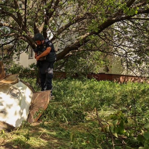 In this photo provided by the Ukrainian Emergency Service, a sapper examines a fragment of the Russian missile in a residential neighbourhood following an air attack in Kyiv, Ukraine, Sunday, June 28, 2026. (Ukrainian Emergency Service via AP)