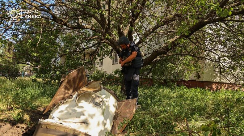 In this photo provided by the Ukrainian Emergency Service, a sapper examines a fragment of the Russian missile in a residential neighbourhood following an air attack in Kyiv, Ukraine, Sunday, June 28, 2026. (Ukrainian Emergency Service via AP)