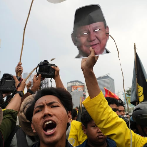 A student protester holds up a mask of Indonesian President Prabowo Subianto during a rally against a fuel price hike, government inefficient spendings, and military involvement in civilian affairs in Jakarta, Indonesia, Friday, June 12, 2026. (AP Photo/Tatan Syuflana)