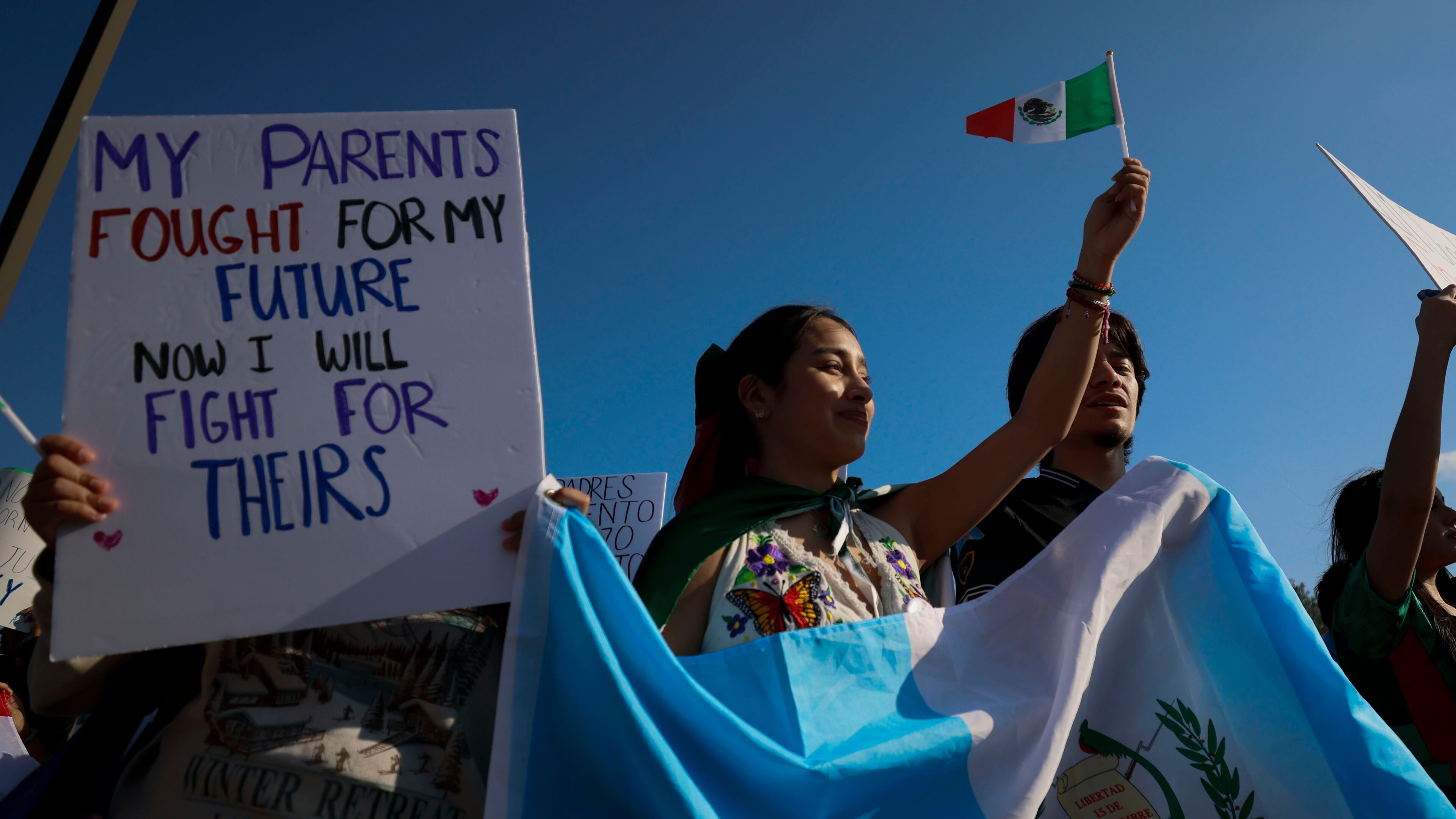 Demonstrators waving Latin American flags in support of immigration gather along Buford Highway in Norcross on Feb. 9, 2025. (Miguel Martinez/AJC)
