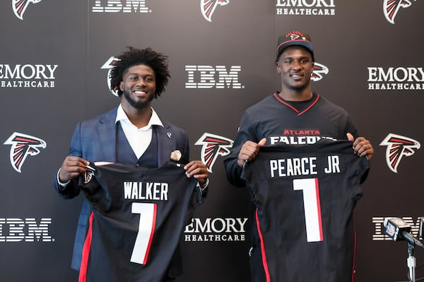 Falcons first round draft picks Jalon Walker (left) and James Pearce Jr. hold up their jerseys during a news conference on Friday, April 25, 2025, in Flowery Branch. (Jason Getz/AJC)