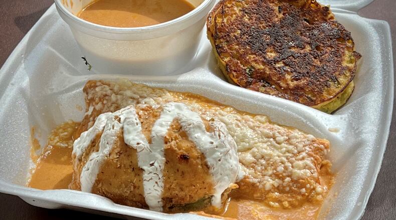 This stuffed avocado order from Taqueria El Vecino features half an avocado stuffed with chicken. It is breaded, deep-fried and sits in a pool of roasted tomato sauce. Henri Hollis/Henri.Hollis@ajc.com